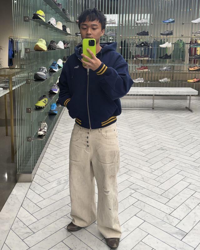 Gerald taking a mirror selfie in a sneaker shop